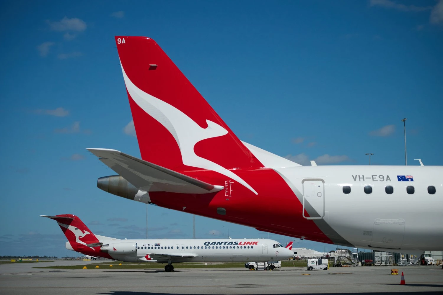 The first QantasLink-owned E190 and, in the background, a Fokker 100